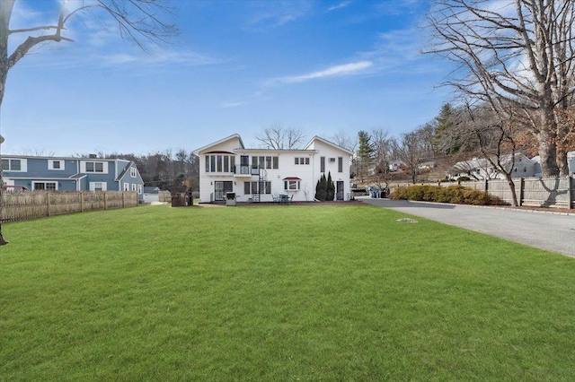 view of front of home with a front lawn and fence