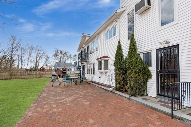 view of patio / terrace featuring stairway, fence, and a wall mounted AC