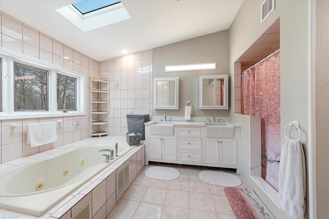 full bathroom with visible vents, a sink, lofted ceiling with skylight, tile walls, and tile patterned floors