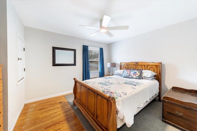 bedroom with light wood-type flooring, baseboards, and a ceiling fan