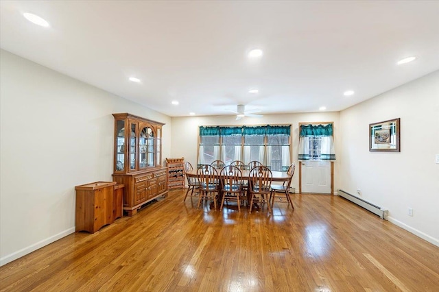 dining area featuring ceiling fan, light wood-type flooring, a baseboard heating unit, and baseboards