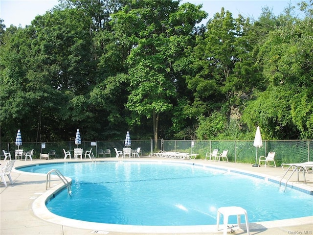 pool featuring a patio area and fence