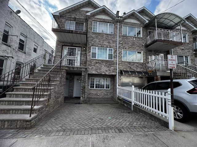 view of property featuring brick siding and stairs