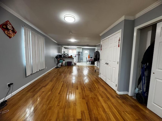 corridor featuring hardwood / wood-style flooring, baseboards, and ornamental molding