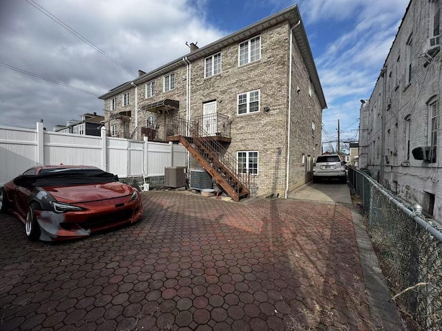 exterior space featuring stairway, cooling unit, and fence