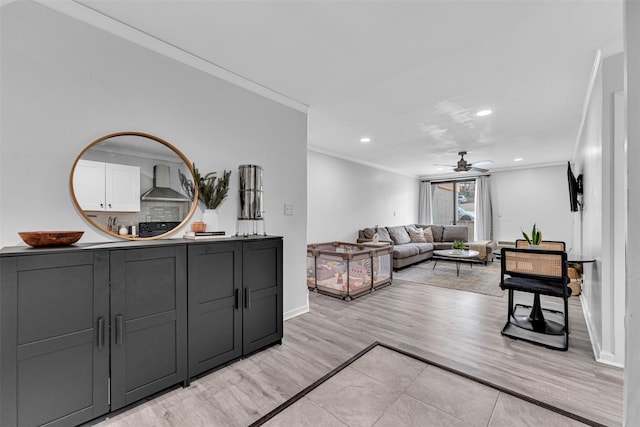 living area featuring a ceiling fan, baseboards, light wood finished floors, recessed lighting, and crown molding