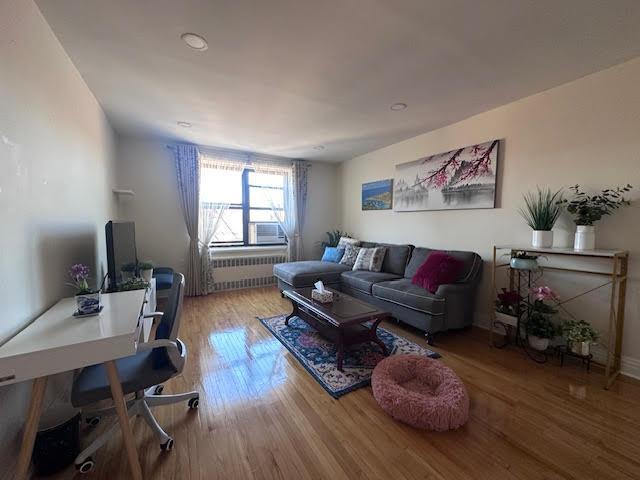 living room with wood finished floors and radiator heating unit