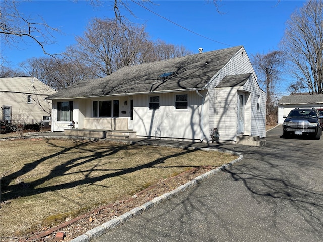 view of front of home featuring aphalt driveway, entry steps, and roof with shingles