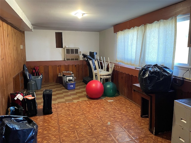exercise room with wood walls, a wainscoted wall, and tile patterned floors