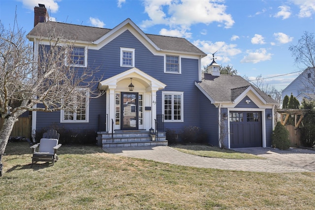 view of front of home featuring a garage, driveway, a front yard, and a chimney