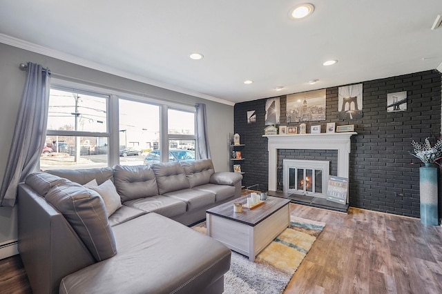 living area featuring recessed lighting, light wood-style floors, a fireplace, and crown molding