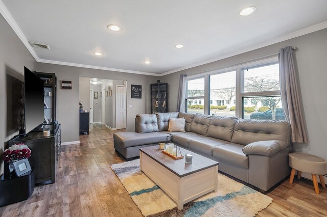 living area with visible vents, recessed lighting, light wood-type flooring, and crown molding