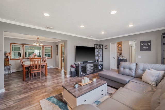 living room featuring visible vents, baseboards, wood finished floors, and ornamental molding