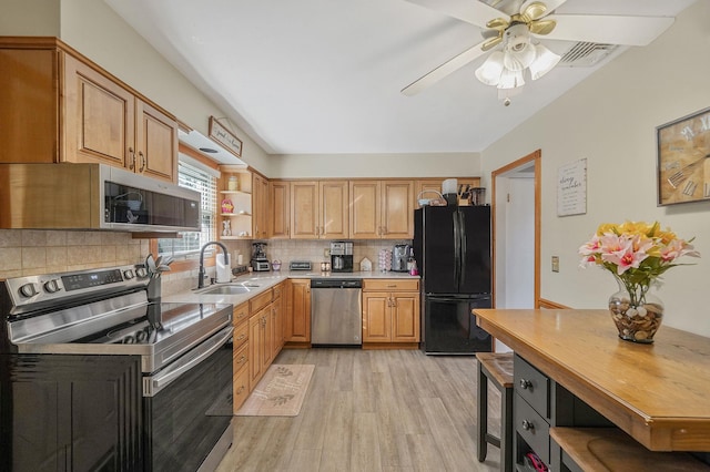 kitchen with open shelves, a sink, stainless steel appliances, tasteful backsplash, and light wood-type flooring