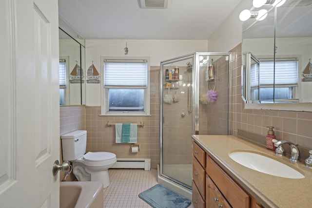 bathroom with tile patterned flooring, tile walls, a stall shower, and a wealth of natural light