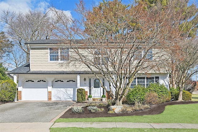 view of front of property with brick siding, an attached garage, driveway, and a shingled roof