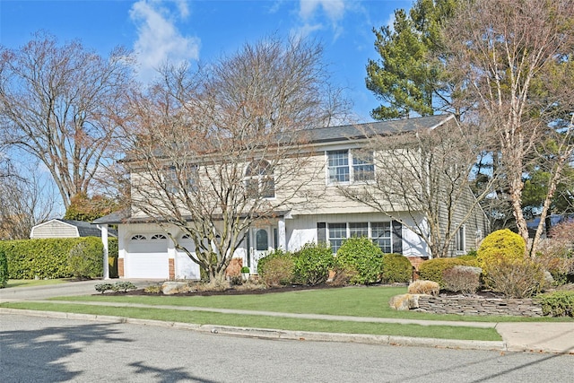 view of front of home featuring a garage, concrete driveway, and a front lawn