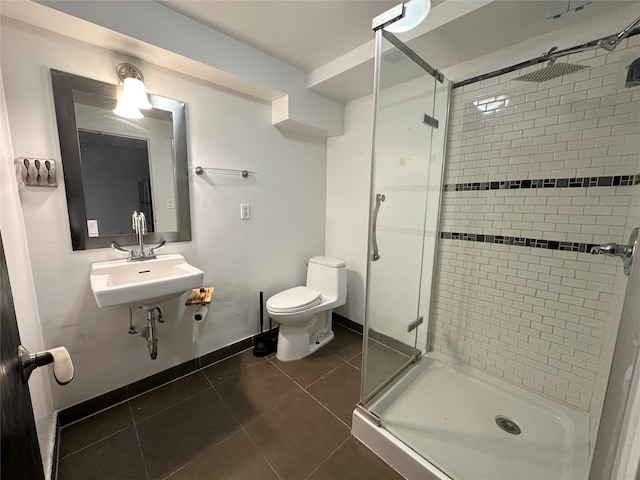 bathroom with tile patterned floors, toilet, a stall shower, and a sink