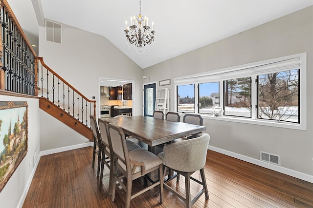 dining area featuring visible vents, an inviting chandelier, hardwood / wood-style floors, and stairs