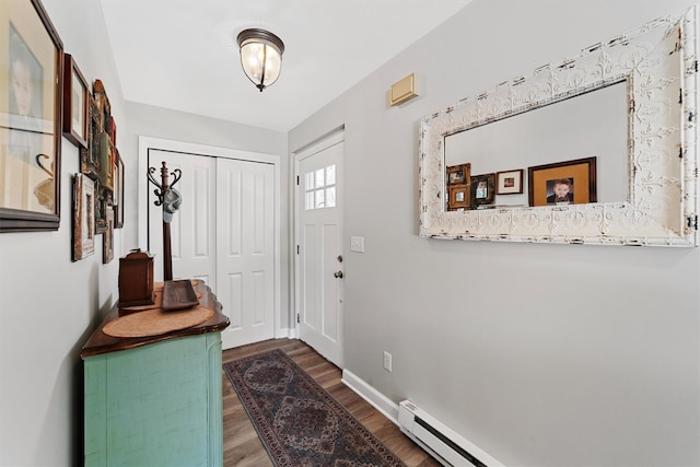 entryway featuring a baseboard radiator, baseboards, and wood finished floors