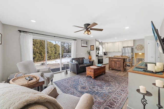 living room with recessed lighting, ceiling fan, and wood finished floors