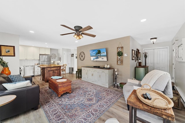 living room with baseboards, recessed lighting, a ceiling fan, and light wood-style floors