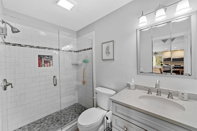 full bathroom featuring vanity, a shower stall, and toilet