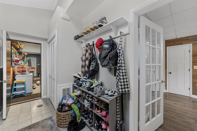 mudroom with tile patterned floors, a drop ceiling, and visible vents