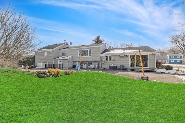 back of property featuring a lawn and central AC unit