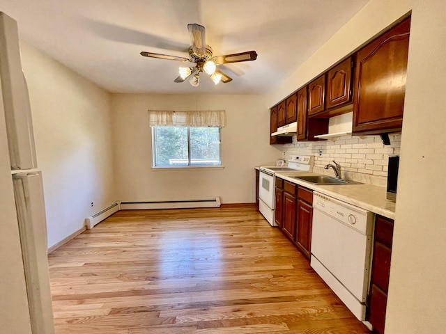 kitchen with light wood-style flooring, a sink, under cabinet range hood, white appliances, and light countertops