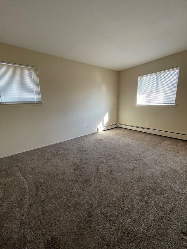 unfurnished room featuring carpet flooring and baseboard heating