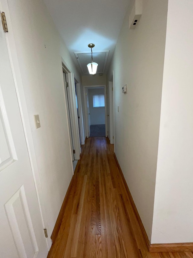 corridor with wood finished floors and baseboards