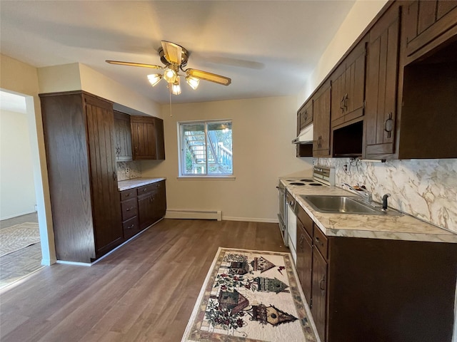 kitchen featuring range with electric cooktop, a sink, a baseboard heating unit, light countertops, and dark brown cabinets