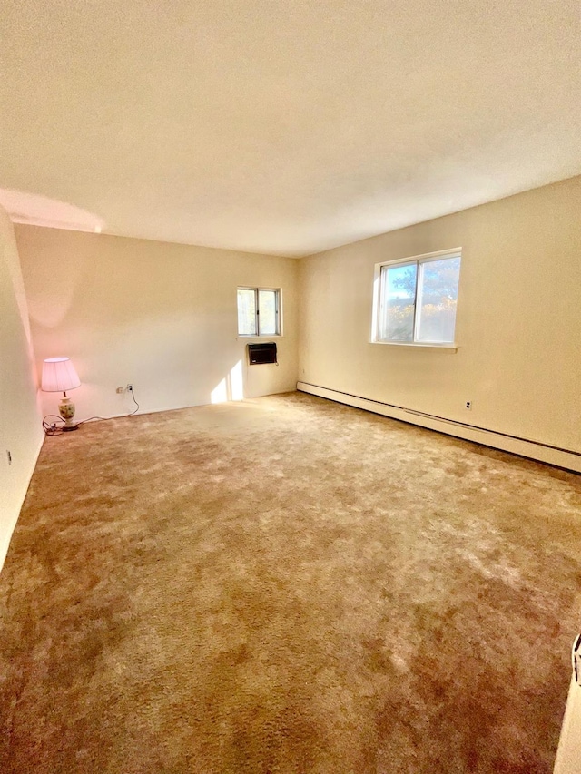 unfurnished room featuring baseboard heating, carpet flooring, and a textured ceiling