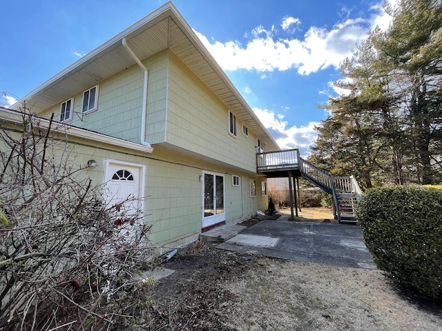 view of side of home with a patio area, stairway, and a wooden deck