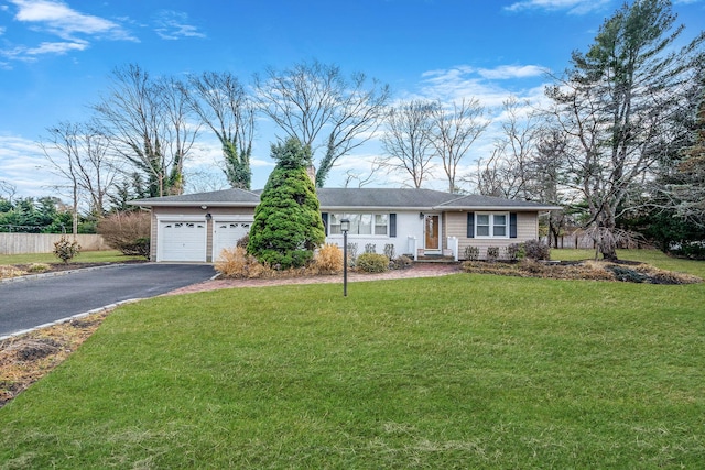 ranch-style house featuring a garage, a front yard, driveway, and fence