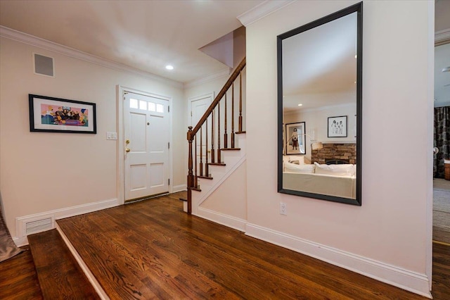 foyer entrance with wood finished floors, visible vents, and ornamental molding