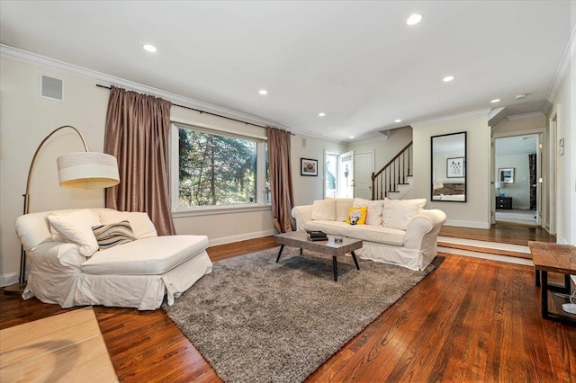 living room featuring stairs, crown molding, wood finished floors, and visible vents