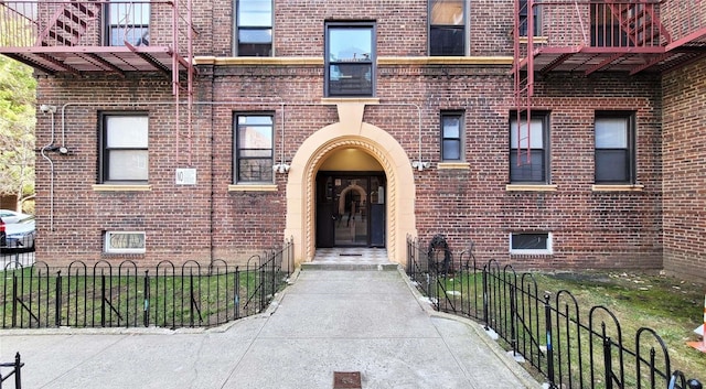 entrance to property with fence and brick siding