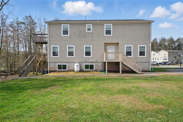 back of property with stairway, a yard, and central air condition unit