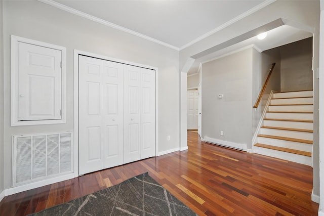 interior space with visible vents, ornamental molding, a closet, a baseboard heating unit, and hardwood / wood-style flooring