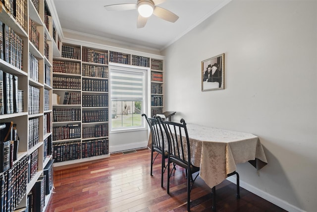 dining area featuring wood-type flooring, a ceiling fan, baseboards, and ornamental molding