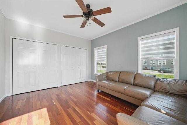 living room featuring crown molding, baseboards, ceiling fan, and hardwood / wood-style floors
