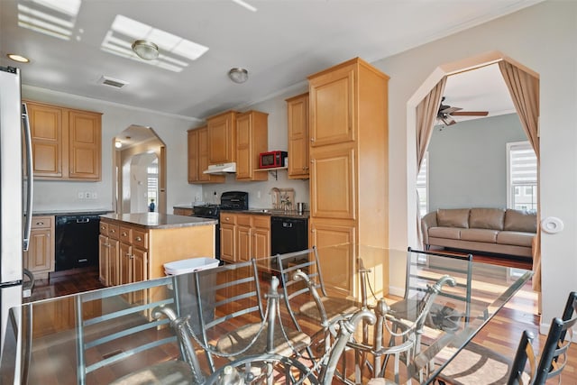 kitchen with dark wood-style flooring, arched walkways, dishwasher, gas stove, and under cabinet range hood