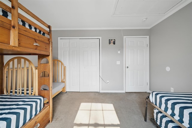 bedroom with crown molding, carpet floors, attic access, baseboards, and a closet