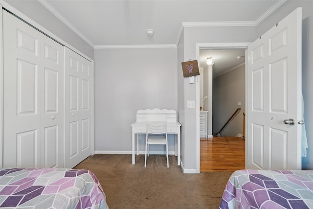 carpeted bedroom featuring crown molding, baseboards, and a closet
