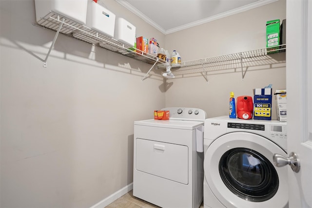 laundry area featuring laundry area, crown molding, baseboards, washer and clothes dryer, and light tile patterned floors