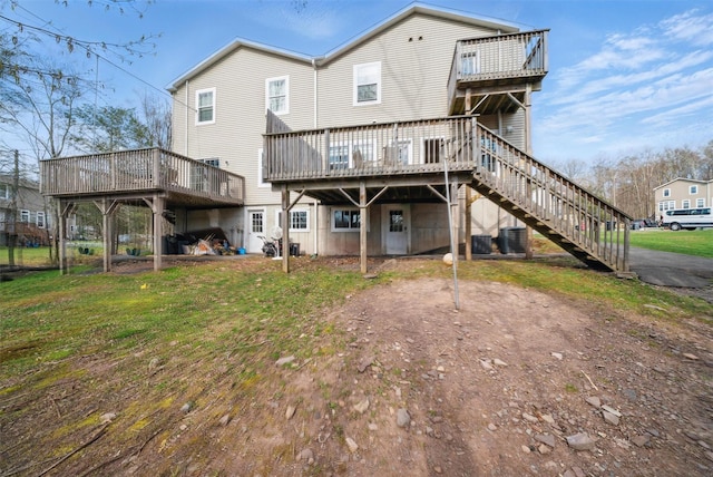 back of house featuring central air condition unit, a wooden deck, and stairs