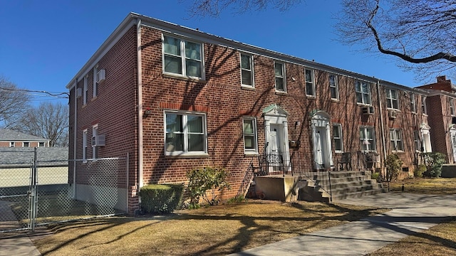 view of front of house with brick siding, fence, and a gate