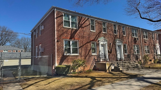 view of front of house featuring brick siding, fence, and a gate